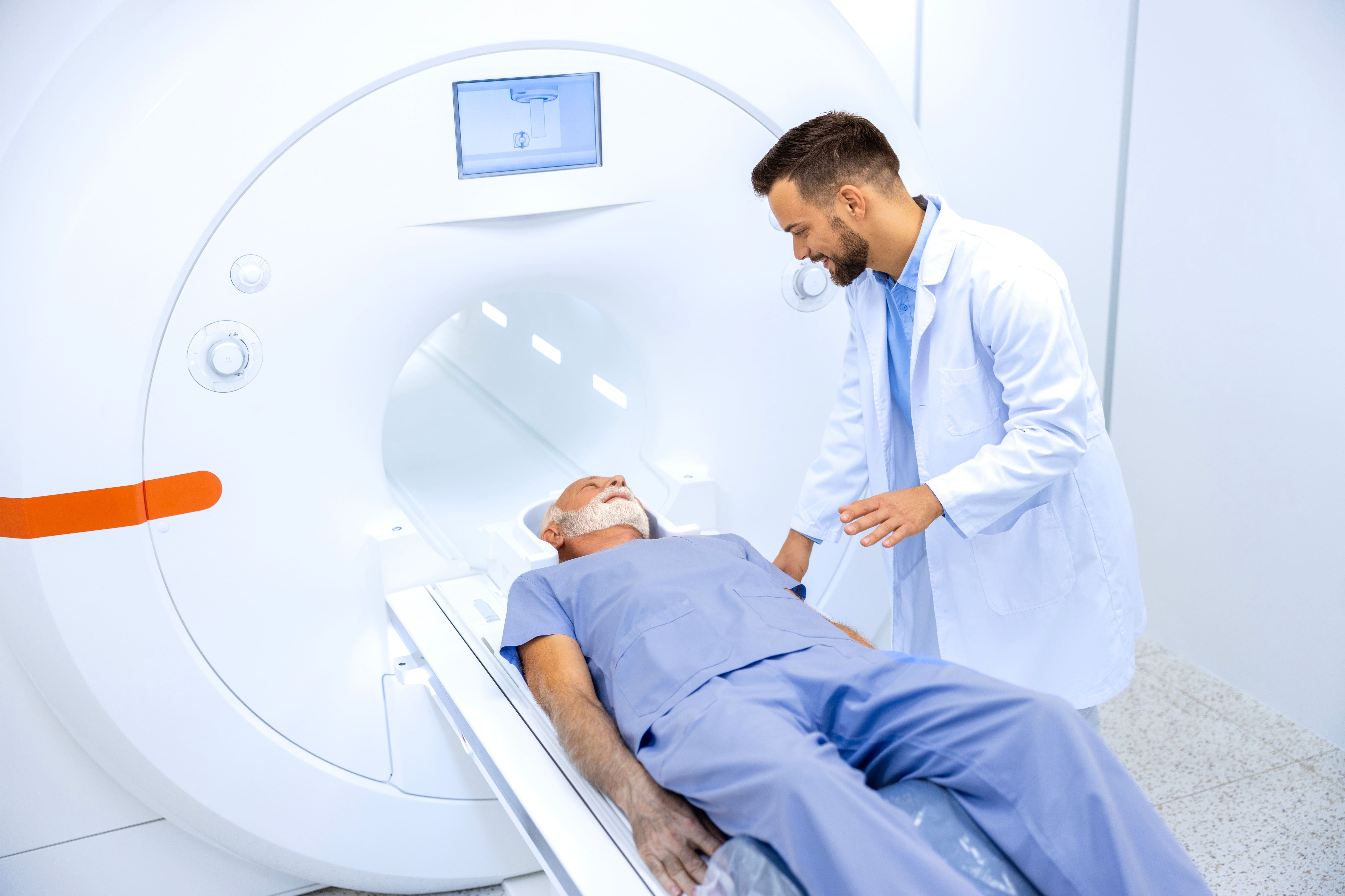 Older adult being assisted into an MRI machine